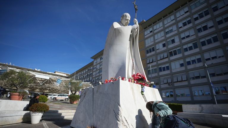 A woman kneels at the foot of a statue of late Pope John Paul II outside the Agostino Gemelli Polyclinic in where Pope Francis was hospitalised Friday after a week-long bout of bronchitis.
Pic: AP