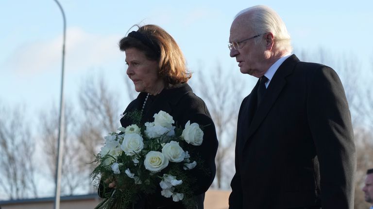Sweden&#39;s King Carl XVI Gustaf and Queen Silvia arrive to place flowers at a memorial near the scene of a shooting on the outskirts of Orebro, Sweden
