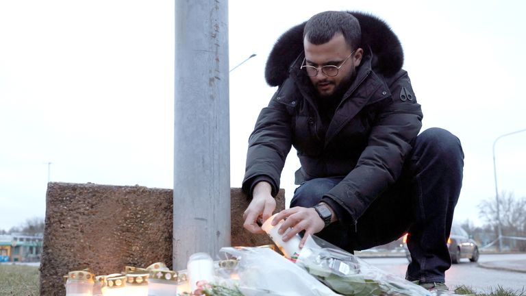 A man lights a candle near the Campus Risbergska school, following a deadly shooting attack at the adult education center in Orebro, Sweden, February 5, 2025. REUTERS/Kuba Stezycki.