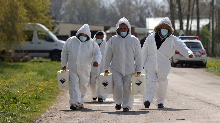 Authorities carry disinfectant liquid near a farm during an outbreak of foot-and-mouth disease in Dunakiliti, Hungary. Pic: Reuters