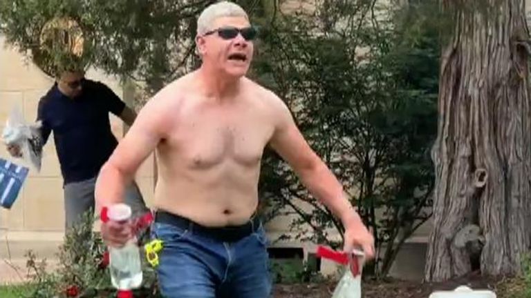 Topless attack suspect holds bottles